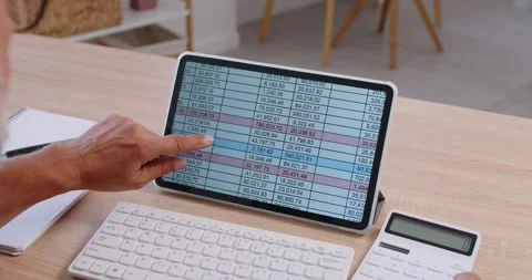 Finger pointing at tablet spreadsheet with calculator on desk, financial Stock Footage 326863527