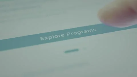 Finger points at the digital button labeled Explore Programs, lifelong learning Stock Footage 328355857