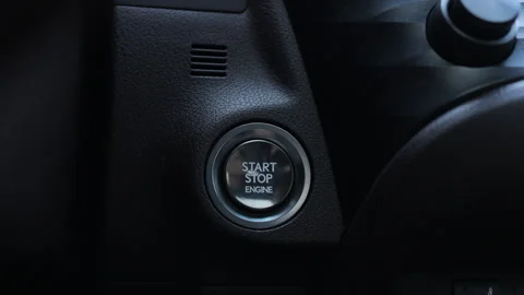 Finger press the button to start the car engine. The driver's hand is pressing Stock Footage 266776969