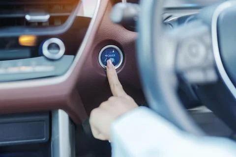 Finger press a car ignition button or START engine inside modern electric a.. Foto stock