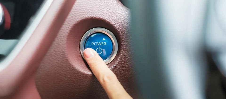 Finger press a car ignition button or START engine inside modern electric a.. Stock Photos