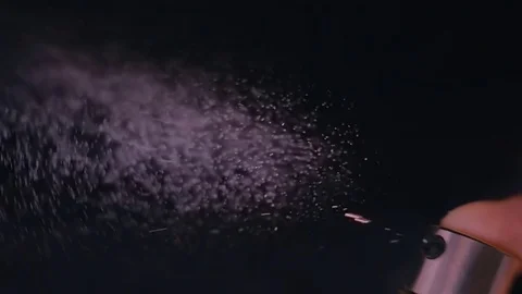 The finger presses the bottle cap with perfume and liquid flies in small drops Stock-Footage 82714895