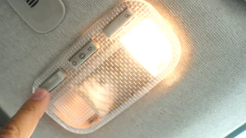 The finger presses the button and then the light in the car is turned on Stock Footage 146825861