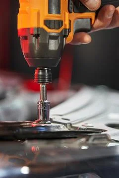 Finger presses the button to start the wrench close-up. the head unscrews the Fotos de archivo