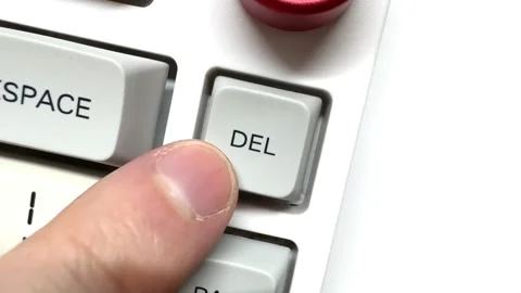 Finger presses the Delete button many times on the white keyboard, top view Stock Footage 309504320