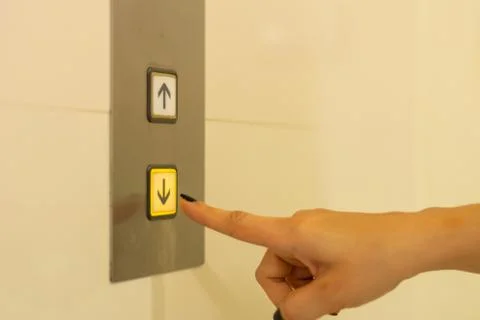 Finger presses the elevator button. hand reaches for the button of the elevat Stock-Fotos
