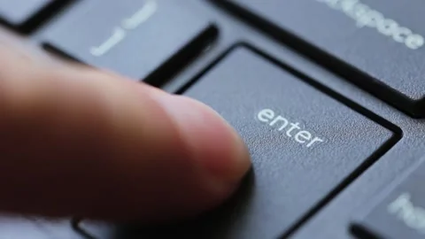 Finger presses the enter key on a modern black desktop pc keyboard. Hitting Stock Footage 151390984