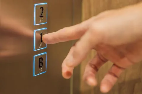 Finger presses the number on the elevator button Foto stock