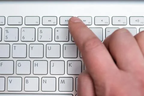 Finger presses the play button Stock Photos