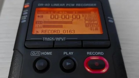 Finger presses record button of digital audio voice dictophone. Screen with wave Stock Footage 219774328