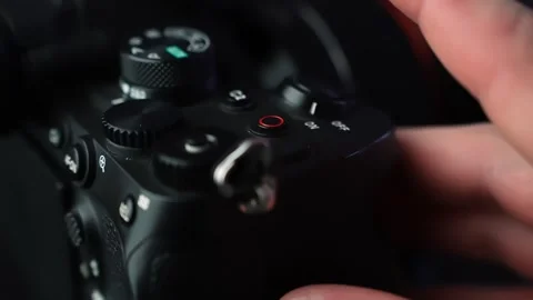 Finger presses the red record button on a mirrorless camera, starting Stock Footage 328974717
