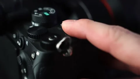 Finger presses the red record button on a mirrorless camera top plate, starting Stock Footage 329480678