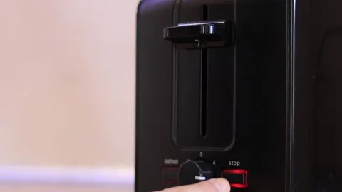 Finger presses the stop button on the toaster. Stock Footage 151357380