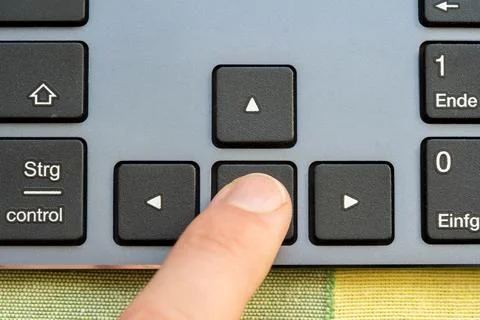 Finger pressing the back arrow key on a computer keyboard, indicating a rev.. Stock Photos