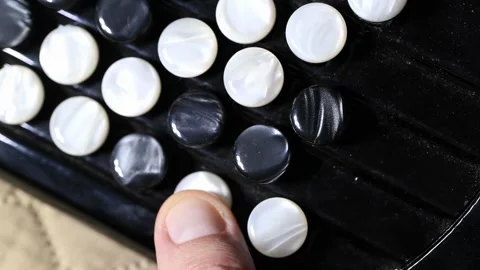 Finger pressing button of accordion style musical instrument close-up view of Stock-Footage 329213181
