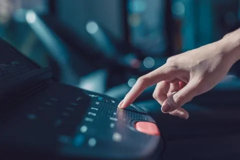 Finger pressing on button of running machine in gym Stock Photos