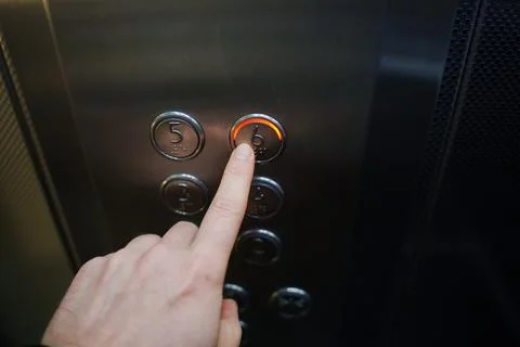 Finger pressing button for sixth floor in elevator at office building 스톡 사진