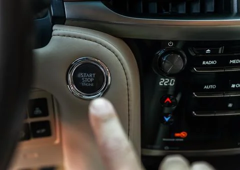 Finger pressing button the start button, stop the engine in the luxury car. T Stock Photos