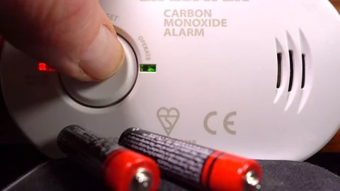 Finger pressing button to test batteries in a carbon monoxide alarm. Vídeos de archivo 104083146