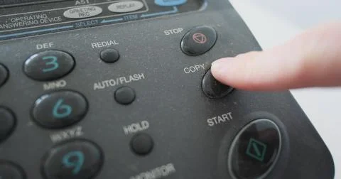 Finger pressing copy button on an old fax machine, close-up, analog transmission Stock Photos