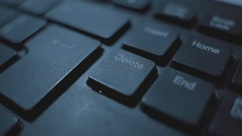 Finger pressing on delete key button on computer keyboard in dark office Video stock 331216068
