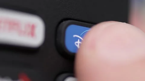Finger Pressing the Disney Plus app Button on a TV Remote Control Closeup Stockbeeldmateriaal 166703919