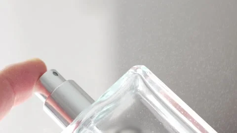Finger Pressing Down on Cologne Spray Bottle to Release Fragrance in Slow Motion Stock Footage 321894716