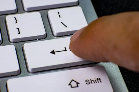 Finger pressing enter key on computer keyboard 스톡 사진