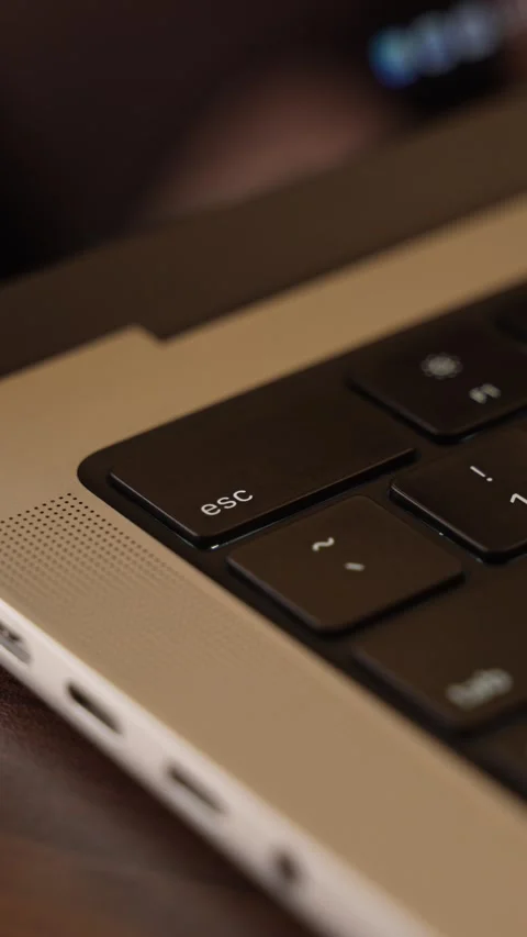 Finger Pressing Escape Key on Laptop Keyboard in Warm Lighted Room Stock Footage 340967809