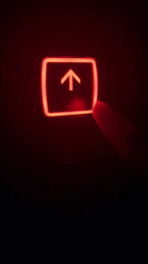 Finger pressing a glowing red up arrow button, activating the elevator and Stock Footage 335645280