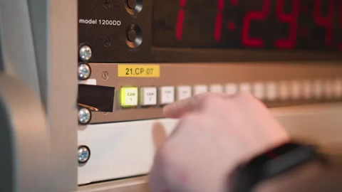 Finger pressing green button on control panel with red timer in studio Stock Footage 317537888