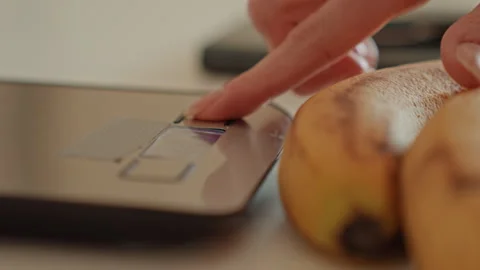Finger pressing kitchen scale near bananas, digital display and buttons visible Stock Footage 342424135