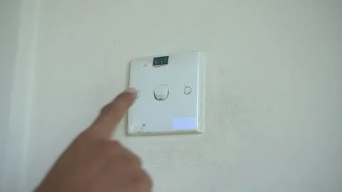 Finger pressing a light switch on the wall inside, symbolizes power, control Stock Footage 322116084