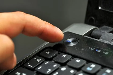 Finger pressing power button Stock Photos