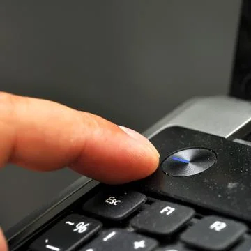 Finger pressing power button Stock Photos