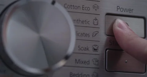 Finger pressing power button on a washing machine Stock Footage 172357365
