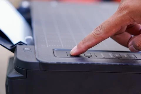 Finger pressing the printer power button Stock Photos