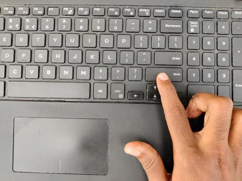 Finger pressing a shift button on the laptop keyboard. Selective focus Stock Photos