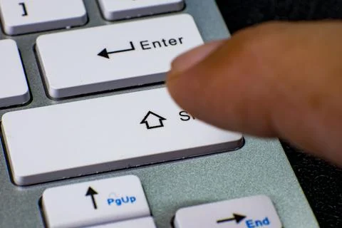 Finger pressing shift key on computer keyboard Stock Photos