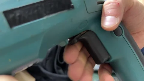 Finger pressing start button on rotary hammer drill handle, powering on Stock Footage 337121673