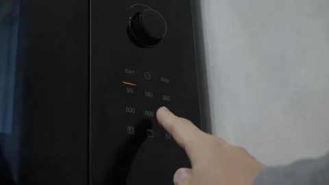 Finger pressing touchpad on microwave control panel Stock Footage 342865162