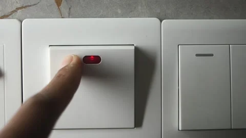 Finger pressing white light switch with red light indicator closeup, turnin.. Video stock 333023811