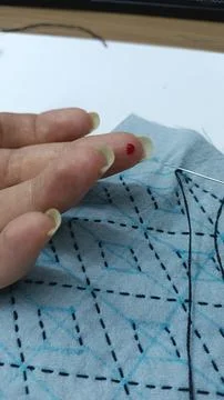 Finger prick while hand sewing sashiko embroidery close up. Fotos Stock