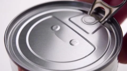 A finger pulling on the ring opens the aluminum lid of the canned food tin Stock Footage 195111763