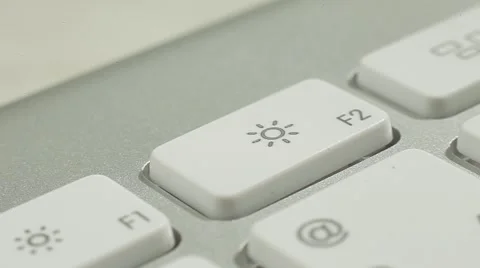 Finger Push F2(sun) Button of the Macbook Keyboard. Close up slow panorama. Stock Footage 50474283