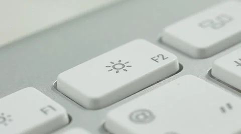 Finger Push F2(sun) Button of the Macbook Keyboard. Close up slow panorama. Stock Footage 50474455