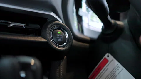 A finger pushes the keyless start-stop button of a new vehicle. Stock Footage 346269300