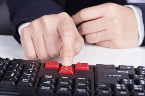 Finger pushing arrow button on keyboard computer Stock Photos
