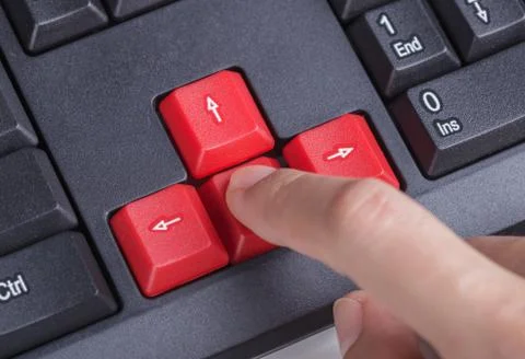 Finger pushing arrow button on keyboard computer Stock Photos