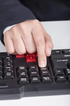 Finger pushing delete button on keyboard of computer Stock Photos